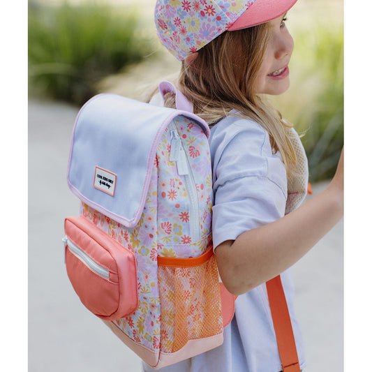 Girl wearing matching Hello Hossy floral backpack and cap set