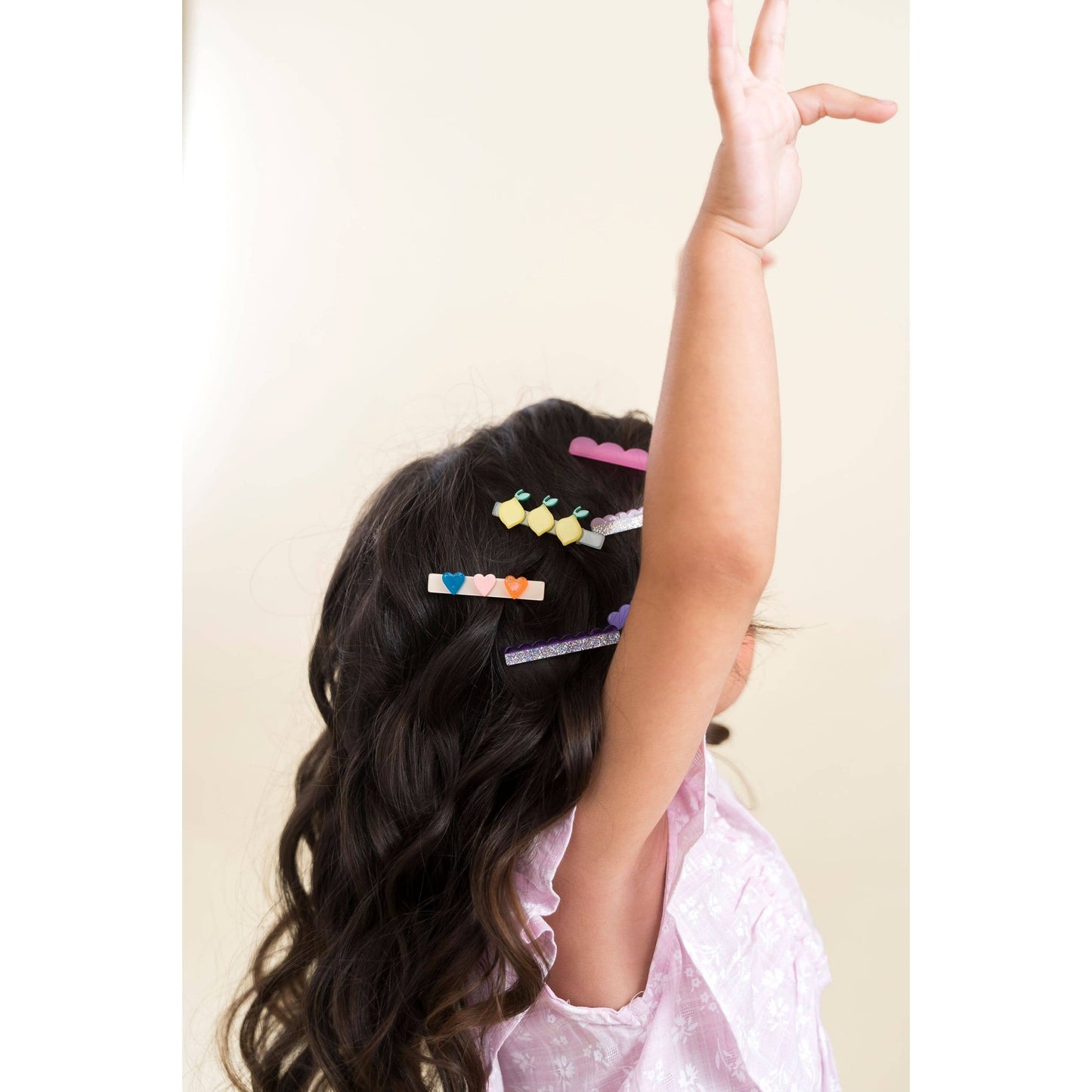 Child wearing lemon heart bird and cloud hair clips