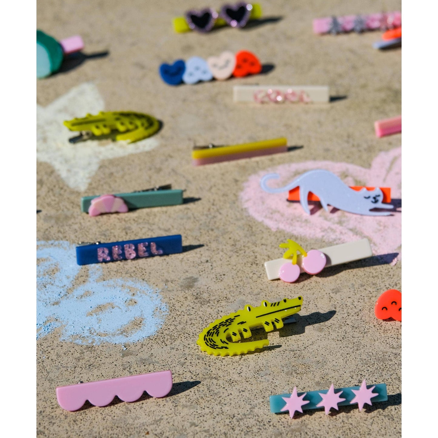 Colorful acetate hair clips including rebel text and animal shapes scattered
