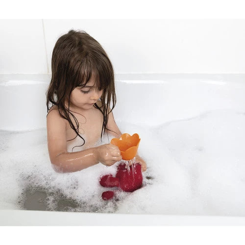 Child pouring water from flower cup into submerged red crab bath toy
