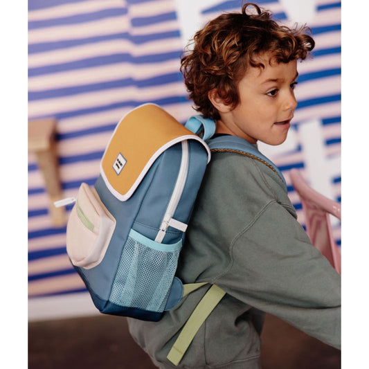 Side-back view of child in curly hair wearing blue kids school bag