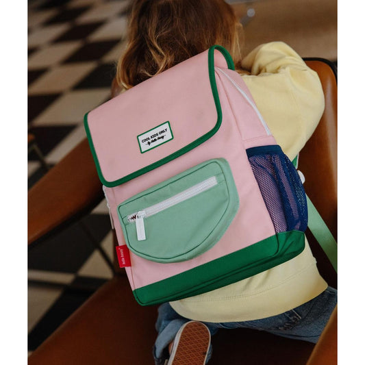 Child modeling pink and green square school backpack from behind