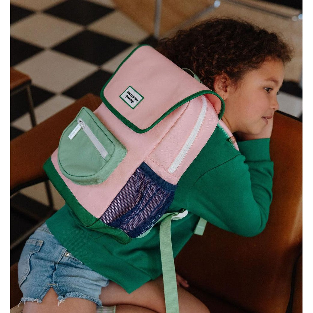 Child wearing pink Mini Smoothie backpack with side profile view