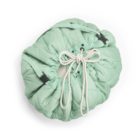 Folded playmat storage bundle with drawstring and mint-green quilted fabric