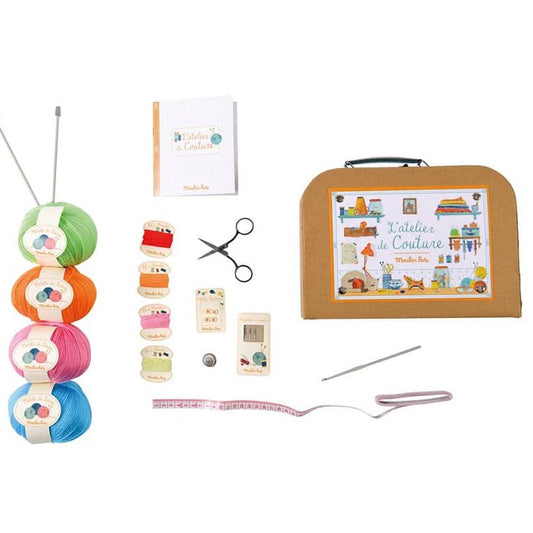 Complete flat-lay of Moulin Roty children's sewing set contents and teal suitcase