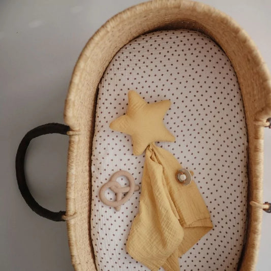 MUSHIES beige pretzel teether inside woven bassinet with muslin liner