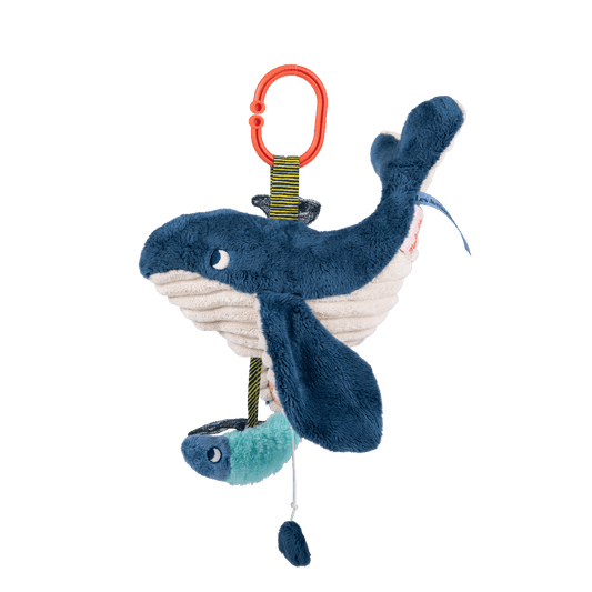 Side view of hanging whale plush with attached fish and pom-pom