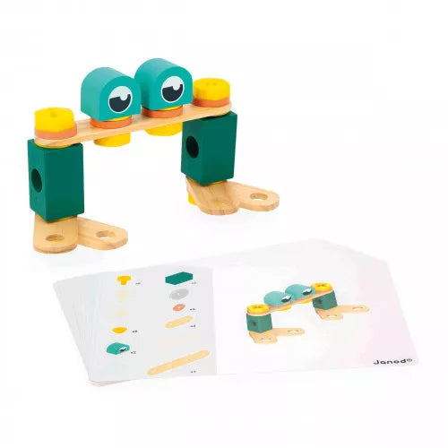 JANOD wooden creature toy with teal dome heads and green blocks alongside assembly guide