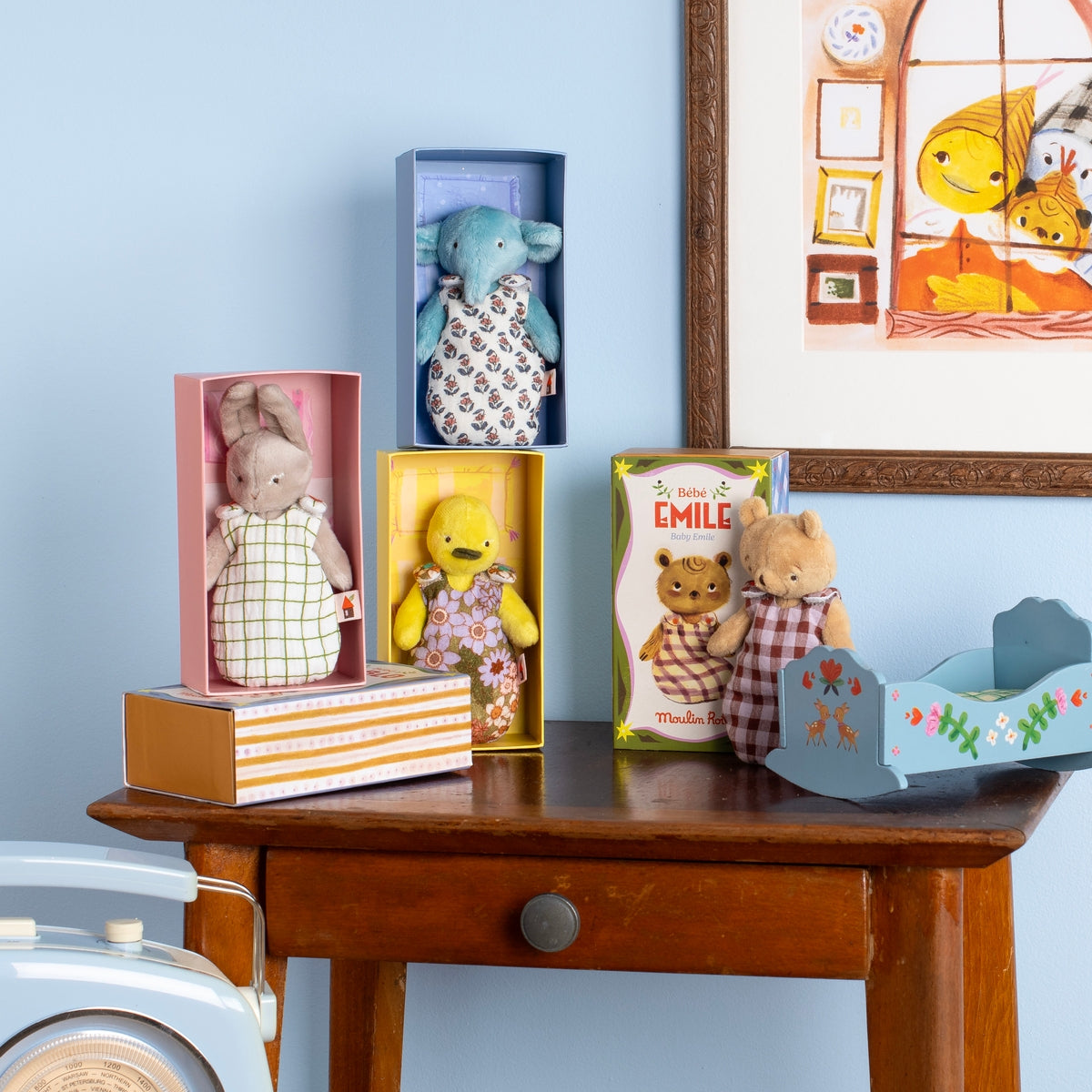 Moulin Roty baby plush toys collection on wooden table with cradle