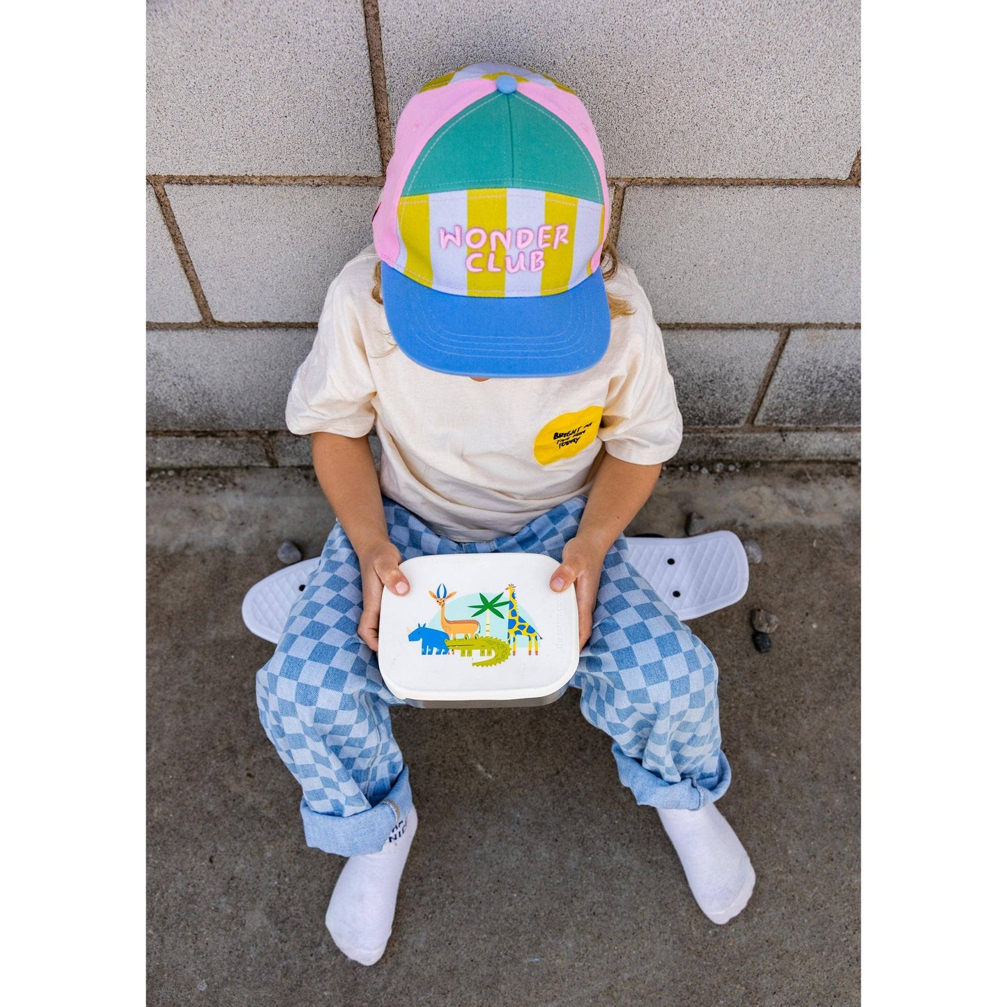 Child holding stainless steel Croc Rock lunchbox with jungle animal lid