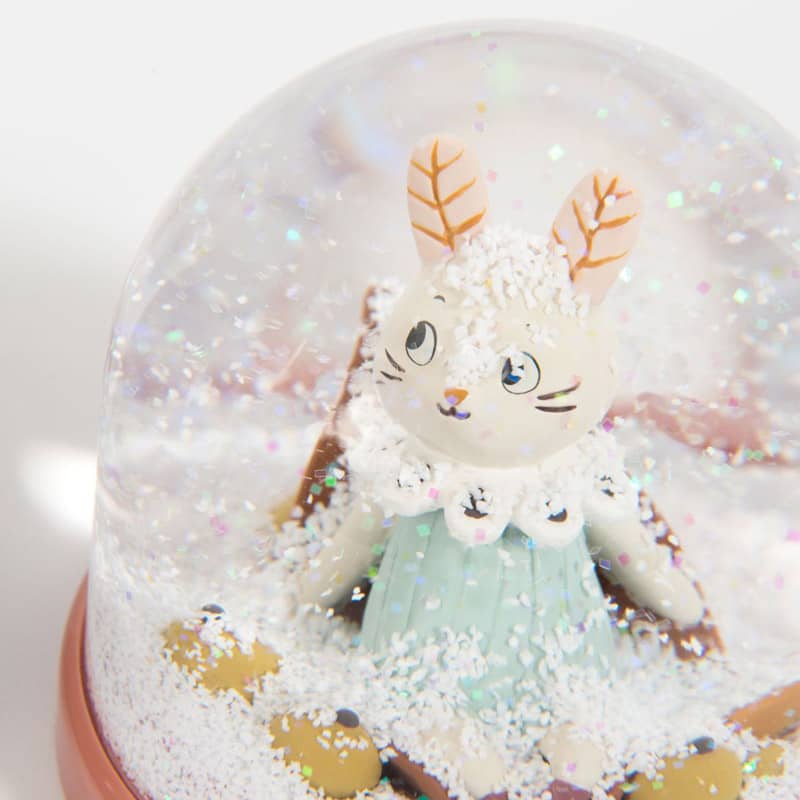 Close-up of Moulin Roty snow globe rabbit with mint dress and autumn leaf details