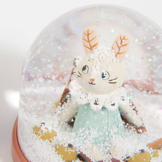 Close-up of Moulin Roty snow globe rabbit with mint dress and autumn leaf details