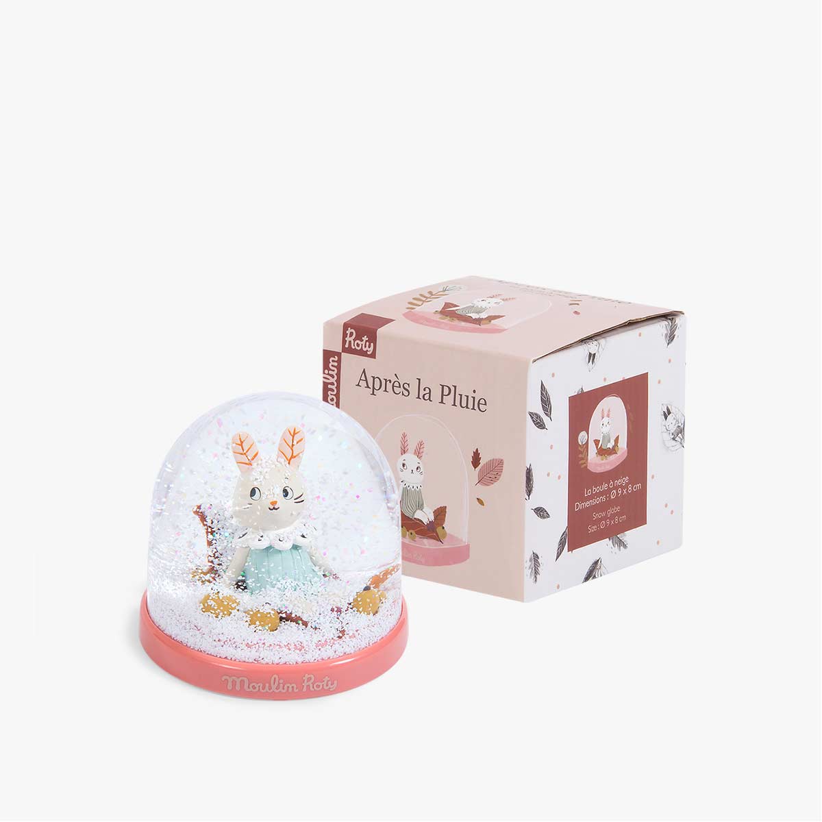 Moulin Roty Après la pluie snow globe next to pink box on white surface