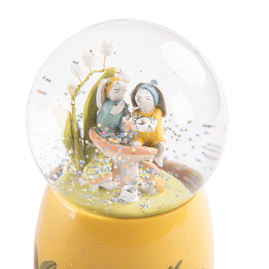 Moulin Roty musical snow globe with rabbits, turtle, and holographic glitter