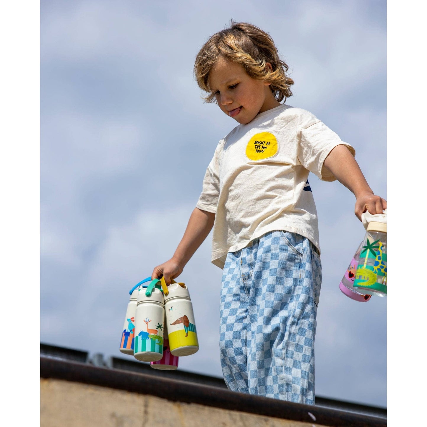 Boy holding multiple animal-themed kids insulated bottles