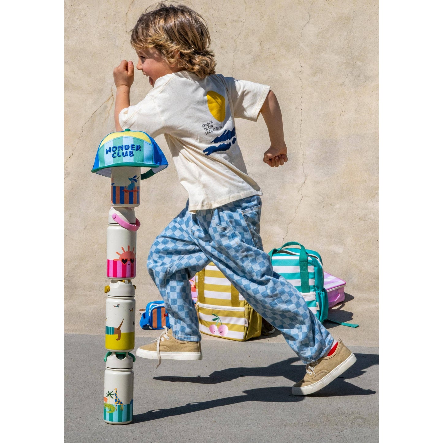 Boy running past stack of four insulated bottles with nature and animal motifs