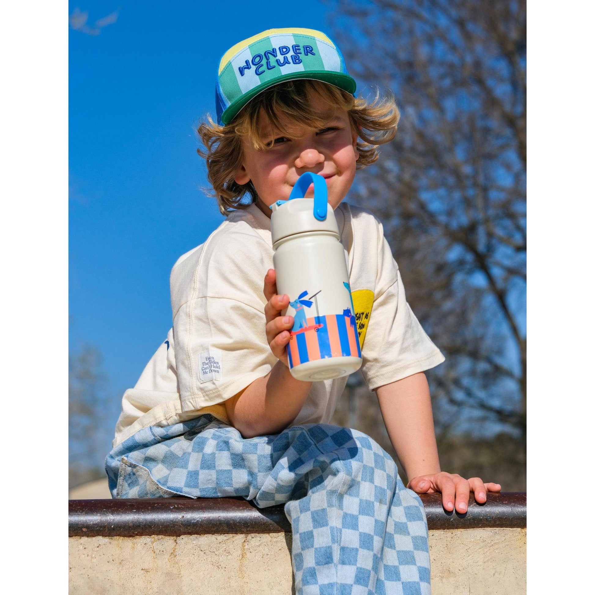 Child drinking from white bottle with bird scooter graphic and blue handle