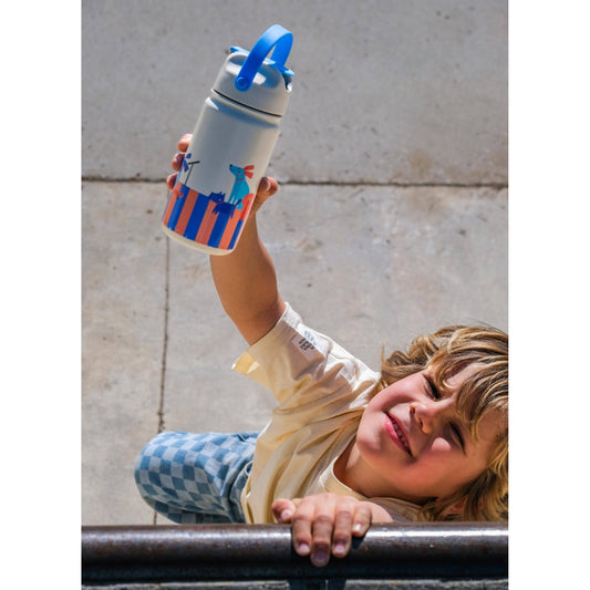 Child holding white insulated bottle with cartoon dogs and orange blue stripes