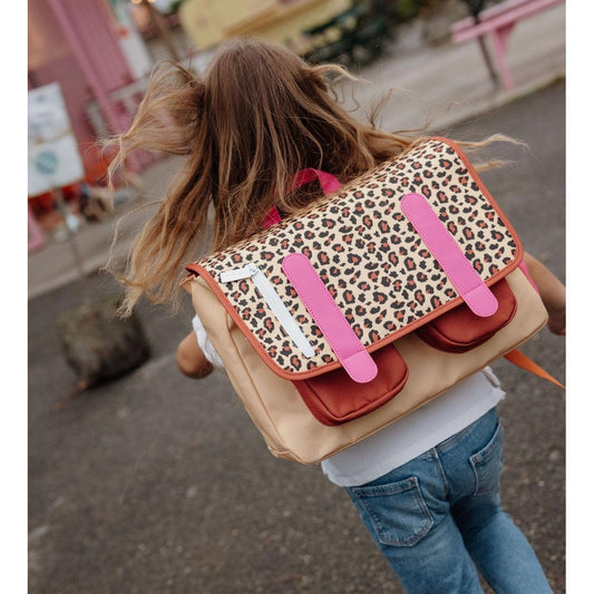 Young girl wearing beige leopard print school bag outdoors
