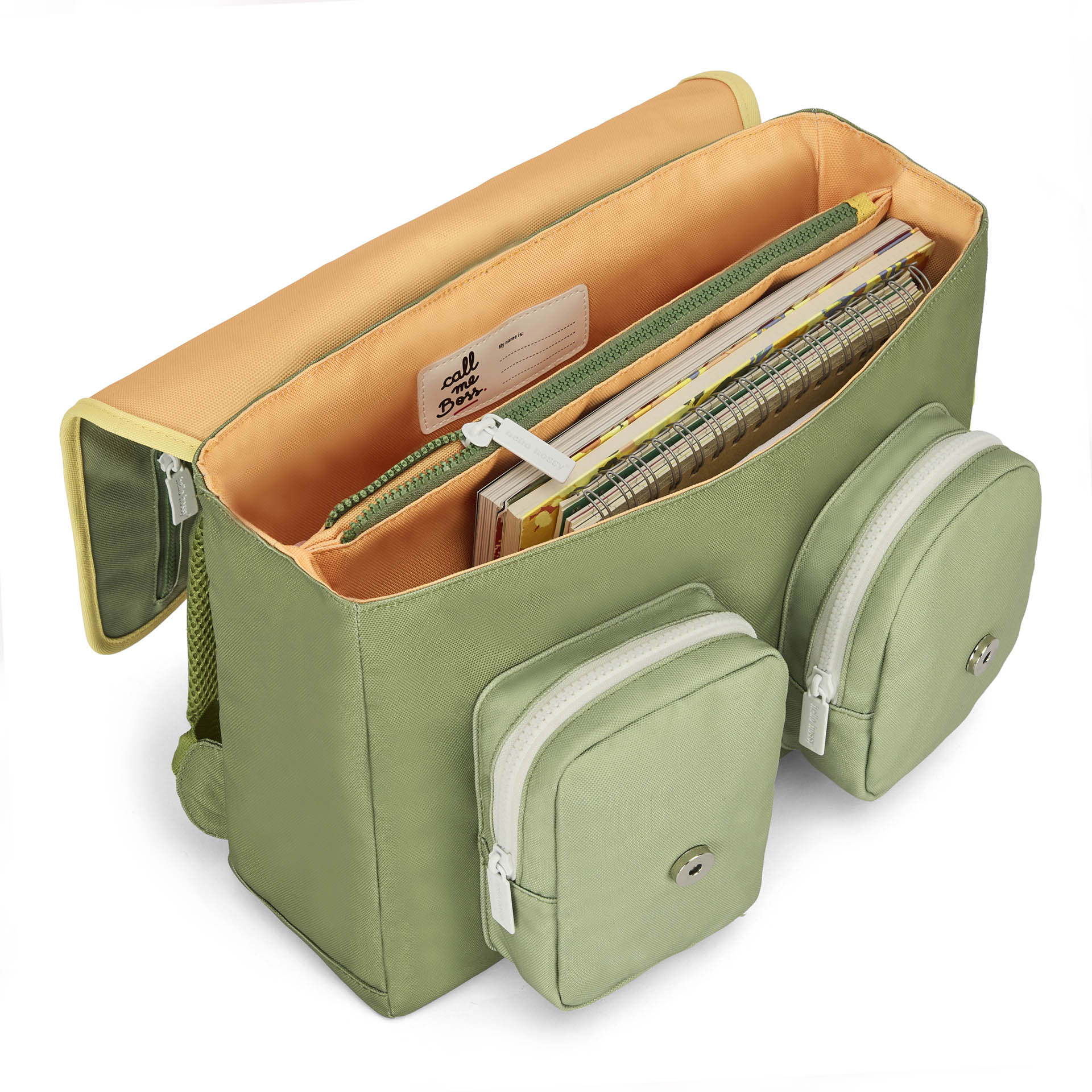 Open green school bag showing 'call me Boss' label and spiral notebooks