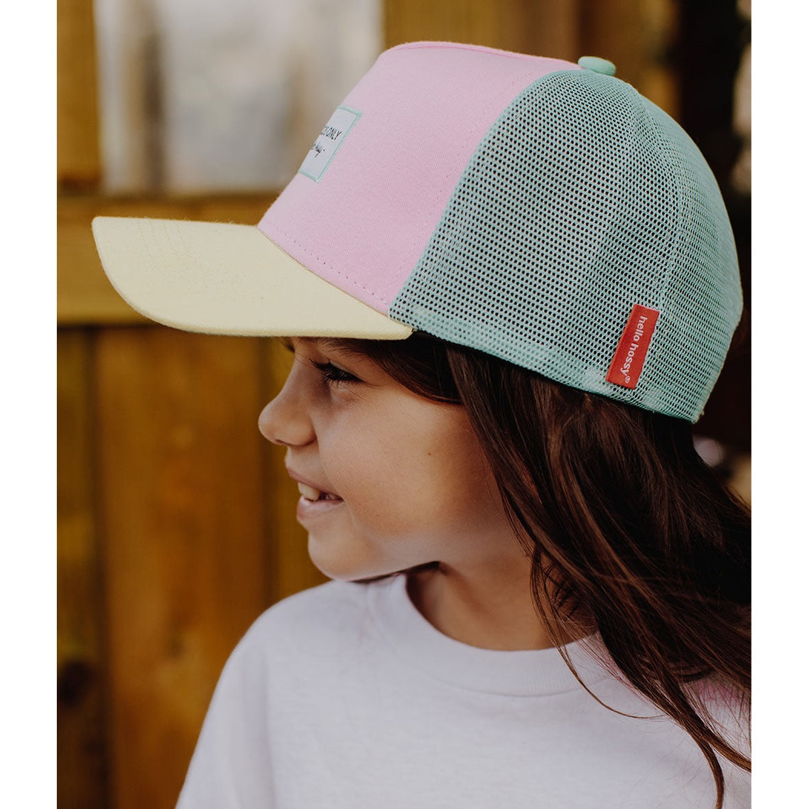 Pink and mint green Hello Hossy trucker cap side view on girl