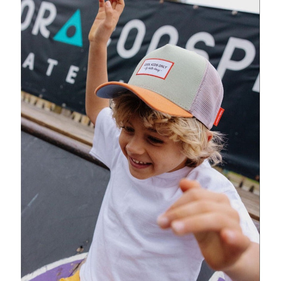 Blonde boy smiling while wearing green and orange Hello Hossy kids trucker hat
