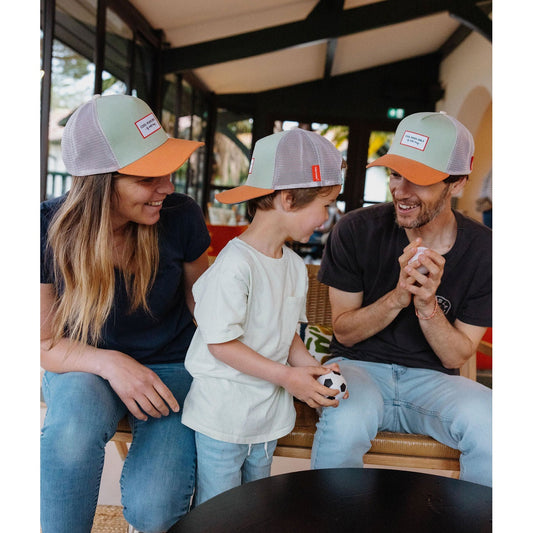 Family of three wearing matching green and orange Hello Hossy kids trucker caps