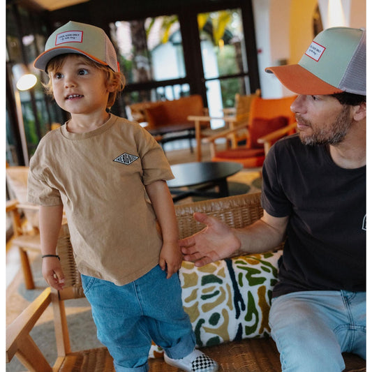 Child and adult wearing matching green and orange Hello Hossy kids trucker caps