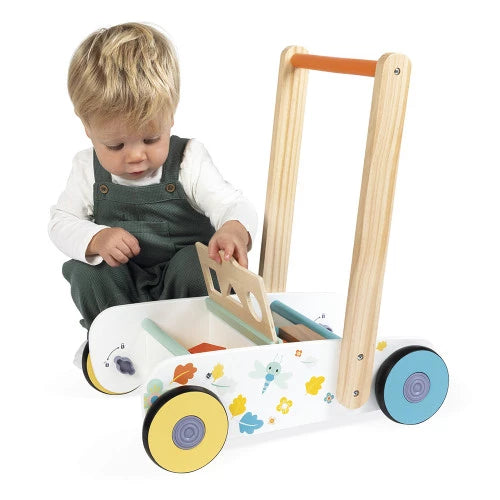 Toddler inserting shapes into Janod wooden walker activity tray