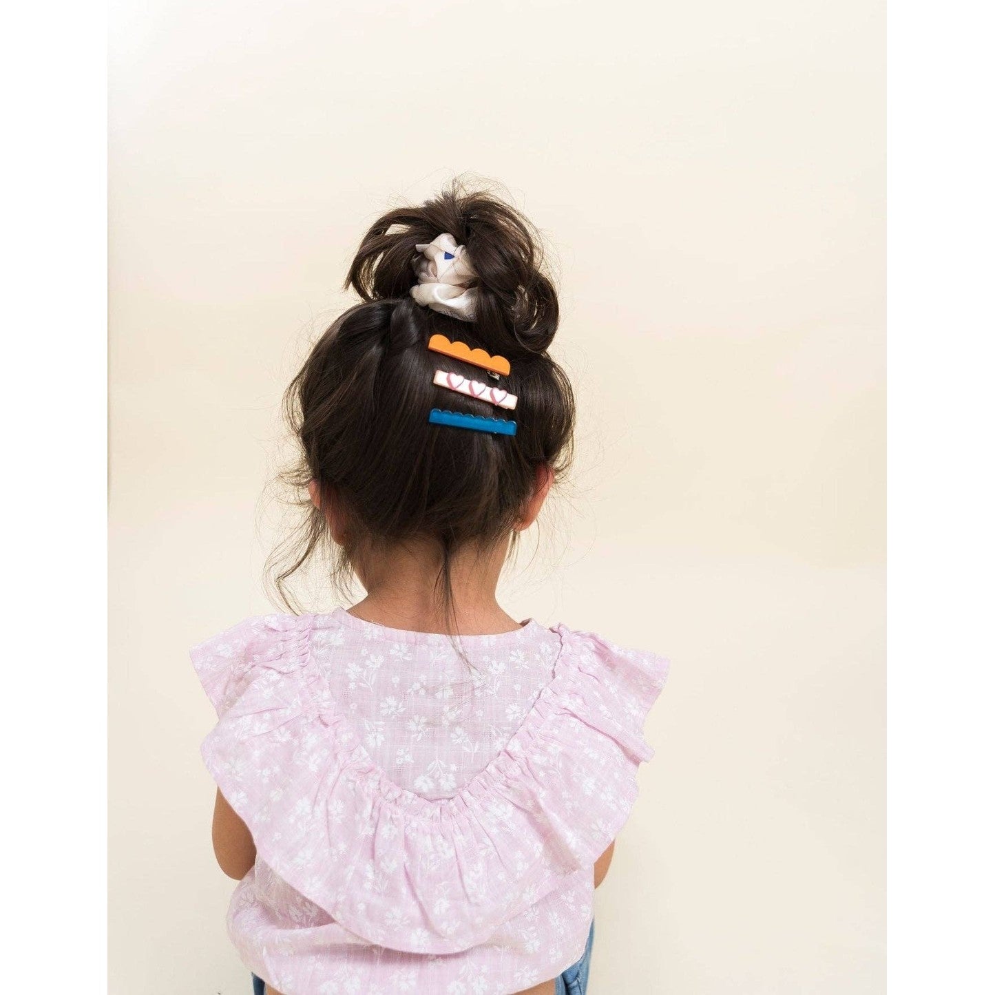 Messy bun secured with white triangular detail scrunchie