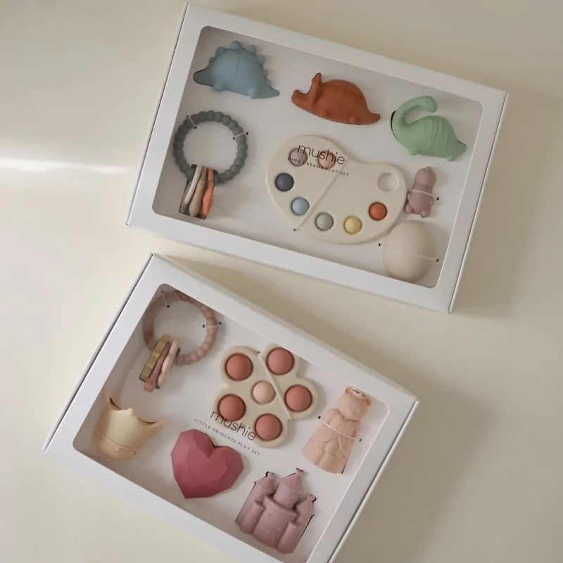 Comparison of MUSHIES Dino Dreams and Little Princess play sets in open boxes