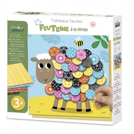 Child placing pink flower felt sticker on farm sheep craft kit box
