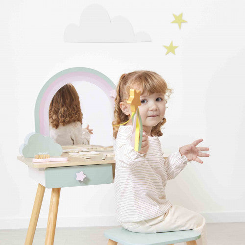 Toddler sitting on matching stool at Janod wooden unicorn vanity with green drawer