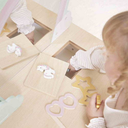 Child using storage compartment in Janod wooden unicorn vanity table top