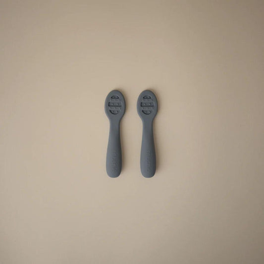 Close-up of textured bowl design on slate blue Mushie baby spoon