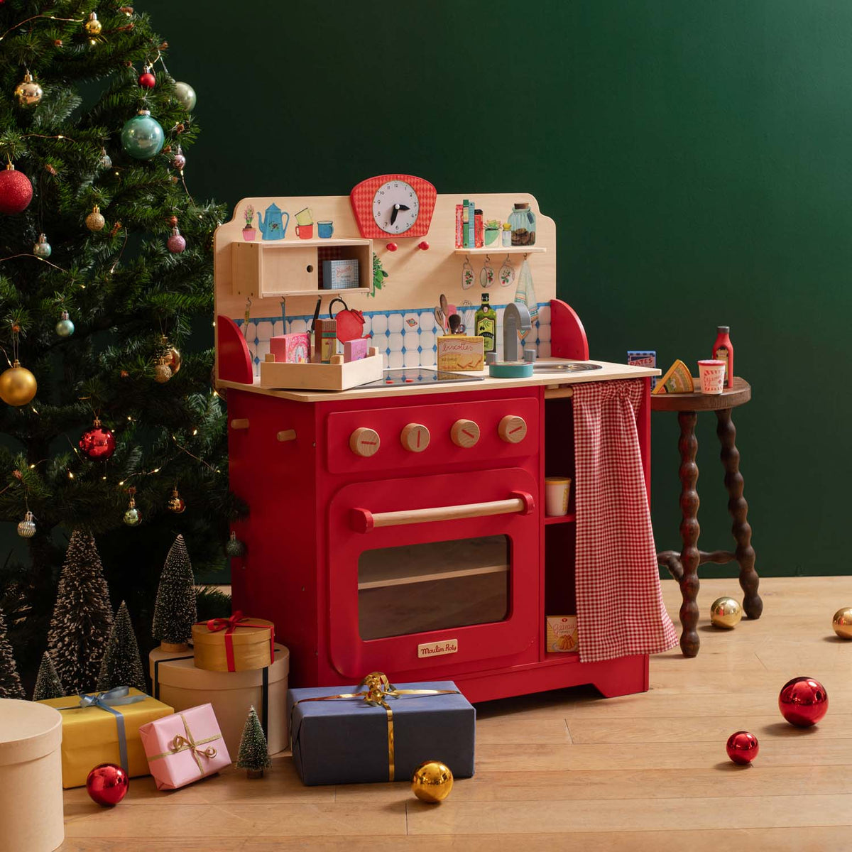 Red wooden play kitchen with lights and sounds in holiday setting