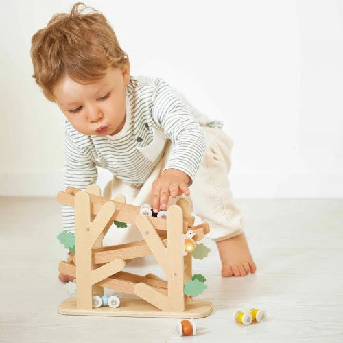 Toddler playing with JANOD wooden ramp toy to develop fine motor skills