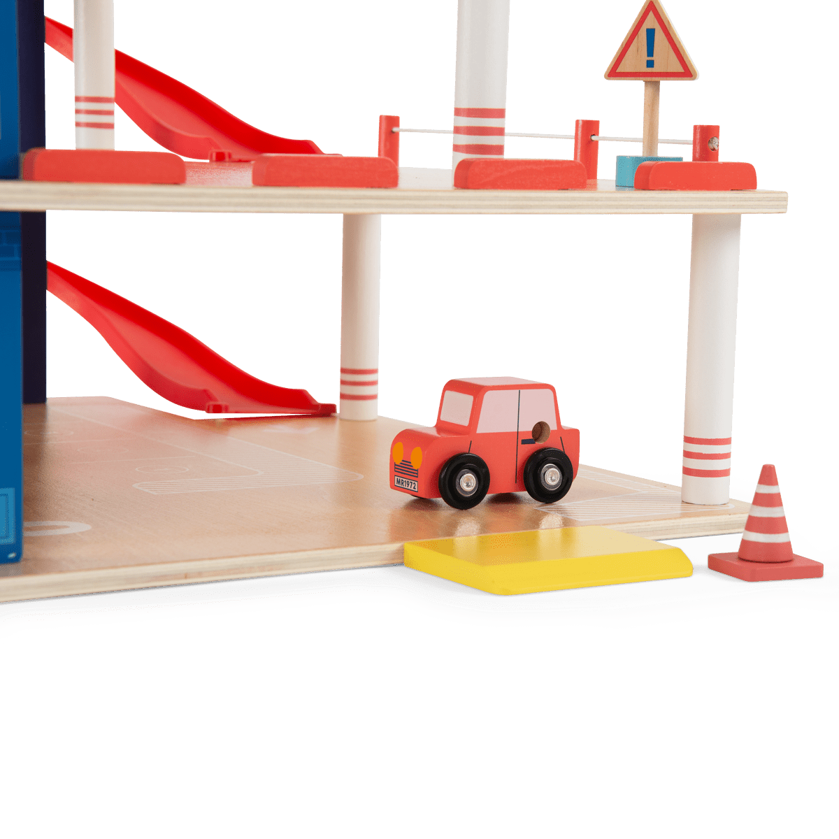 Close-up of wooden toy car and traffic cone accessories on the ground level of the garage set