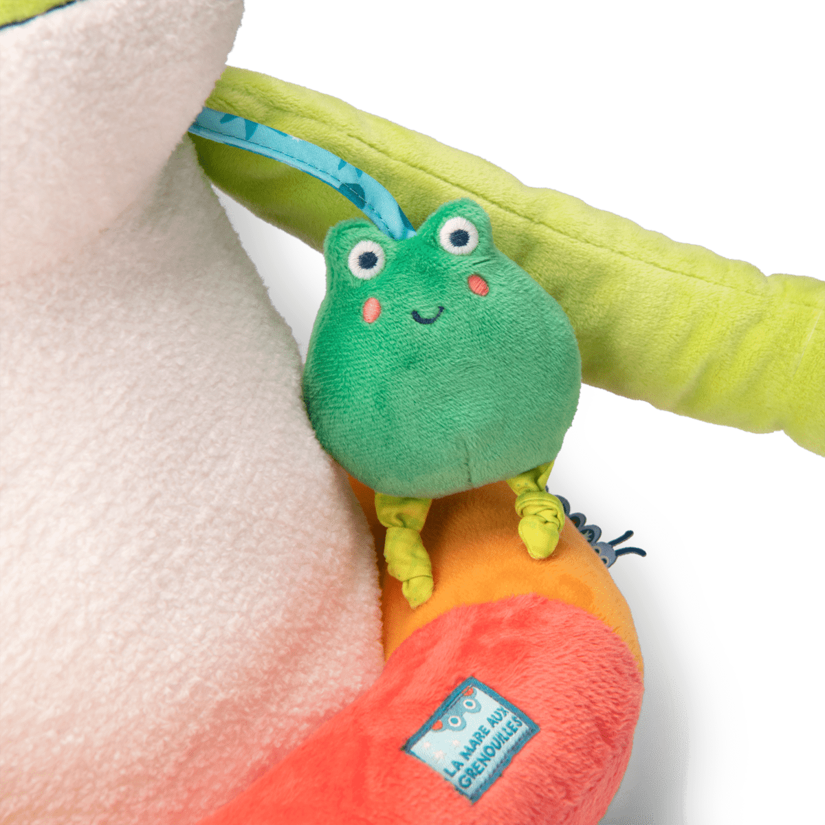 Close-up of small squeaker frog attached to giant plush frog arm