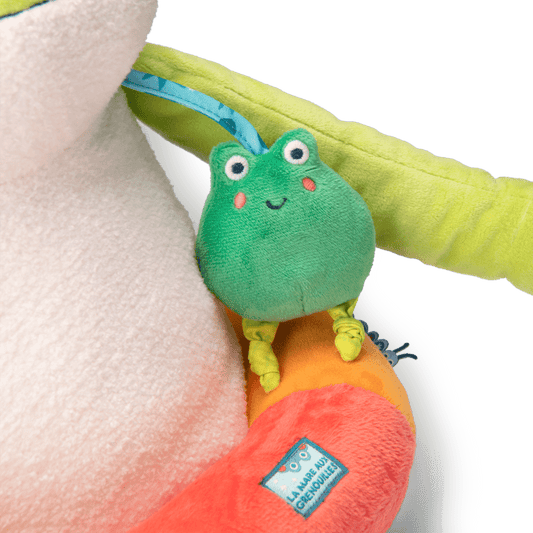 Close-up of small squeaker frog attached to giant plush frog arm
