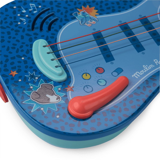 Close-up of toy guitar bridge, colored strings, and star graphics