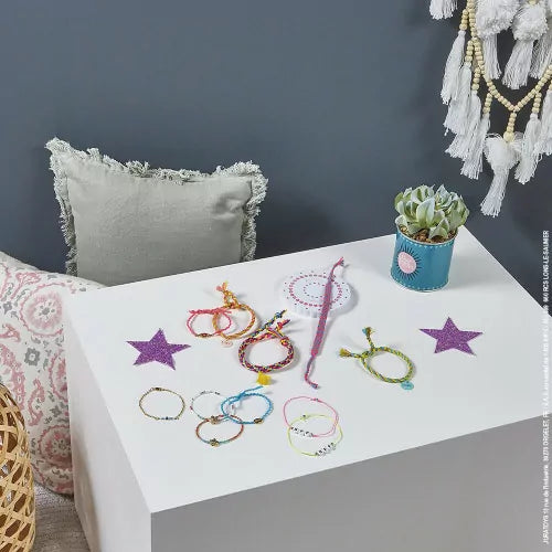 Colorful handmade friendship bracelets with tools on display