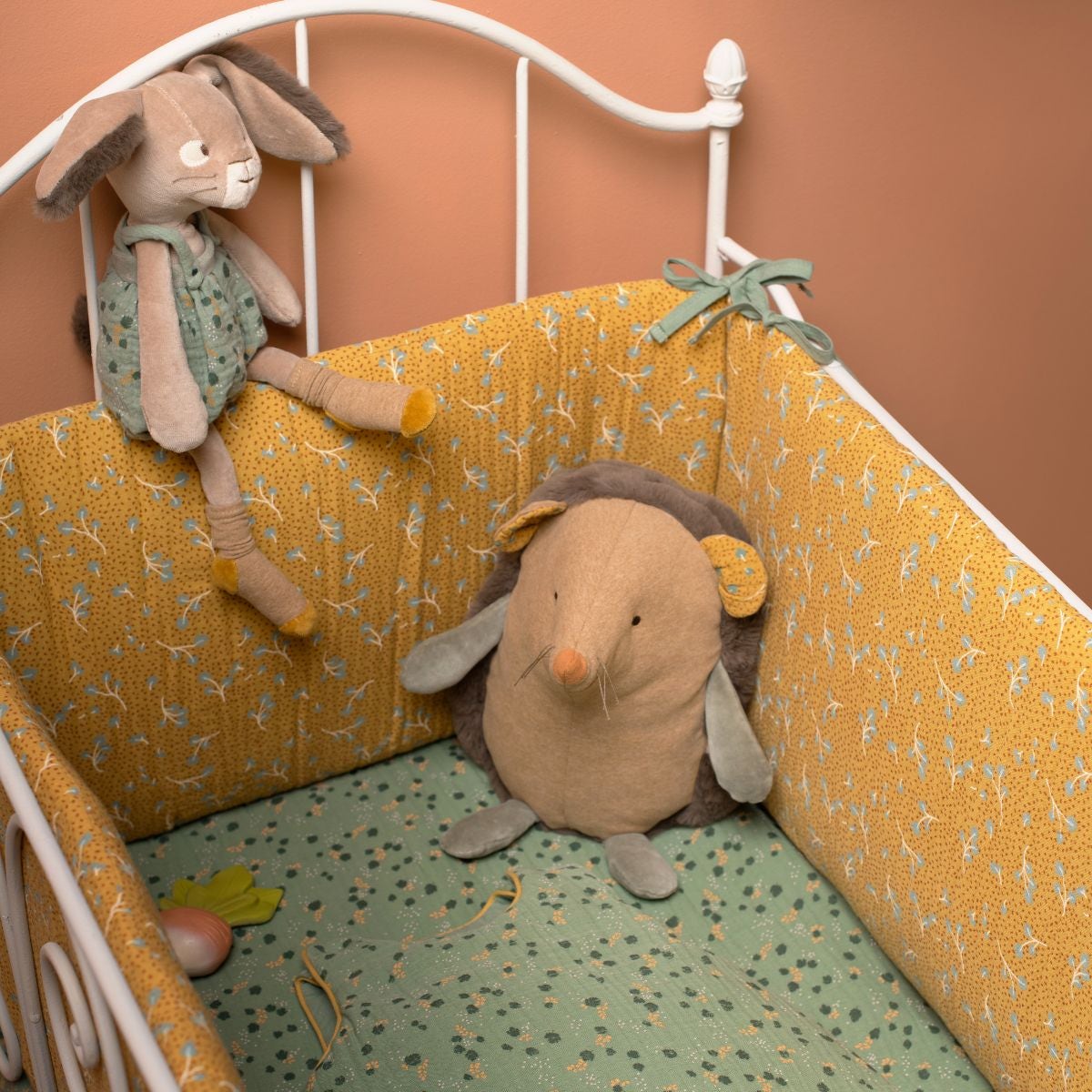 Sage green floral dress plush rabbit on white metal crib