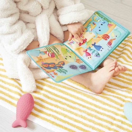 Toddler reading underwater bath book after bath time