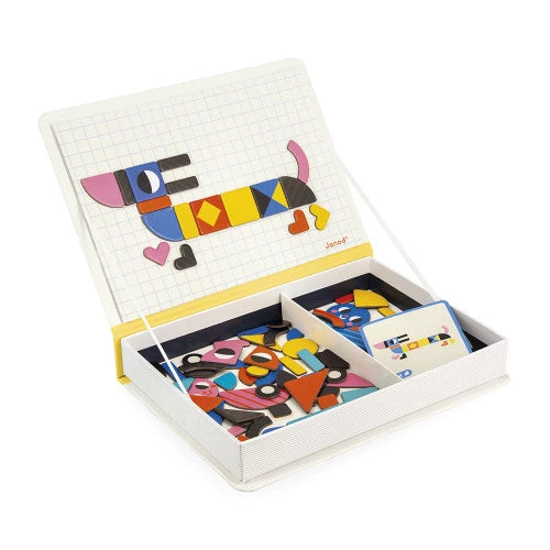 Open JANOD magnetic book showing grid lid with dog figure and tray of colorful magnetic shapes