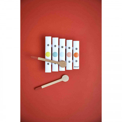 Top view of JANOD wooden xylophone showing five white bars with colored dots and brand logo