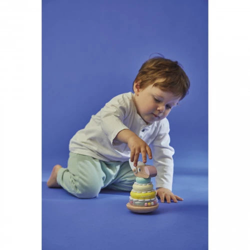 Toddler playing with Janod wooden sheep stacking toy on blue floor
