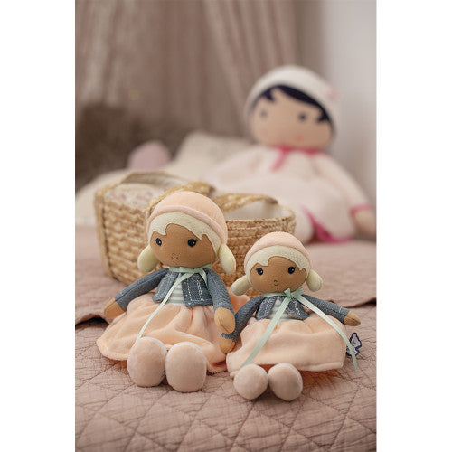 Two KALOO Chloé fabric dolls on pink quilted surface with woven basket background