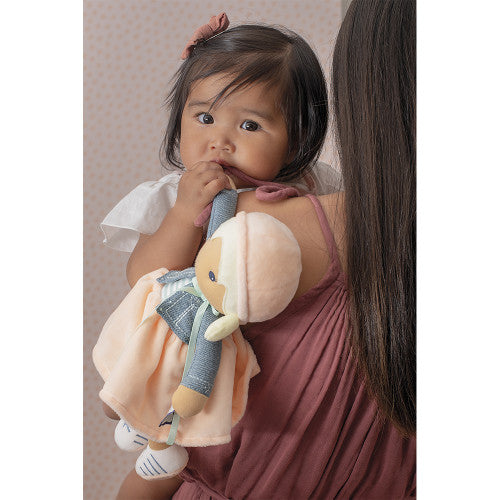 Toddler holding Kaloo Chloé plush doll for gentle play