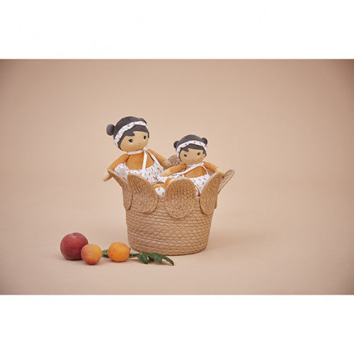 Two Kaloo Éloise dolls in woven basket styled with fresh fruits for nursery decor
